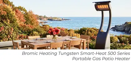 Portable freestanding patio heater beside a teak dining set overlooking the ocean.